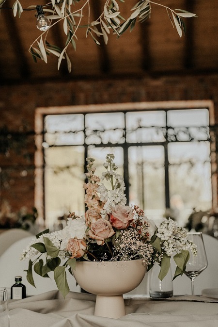 Pastellfarbene Vase auf Tisch mit Blumen