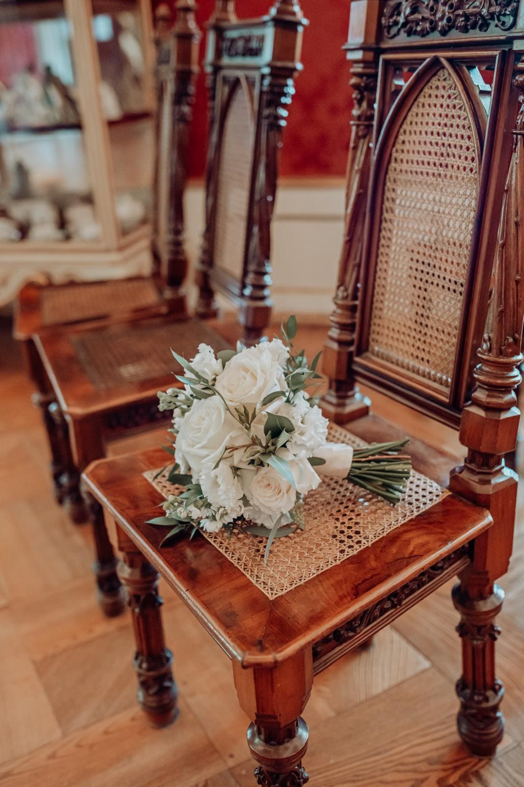 Rustikale, glänzende Holzstühle in der Kirche mit einem hellen Blumenstrauß