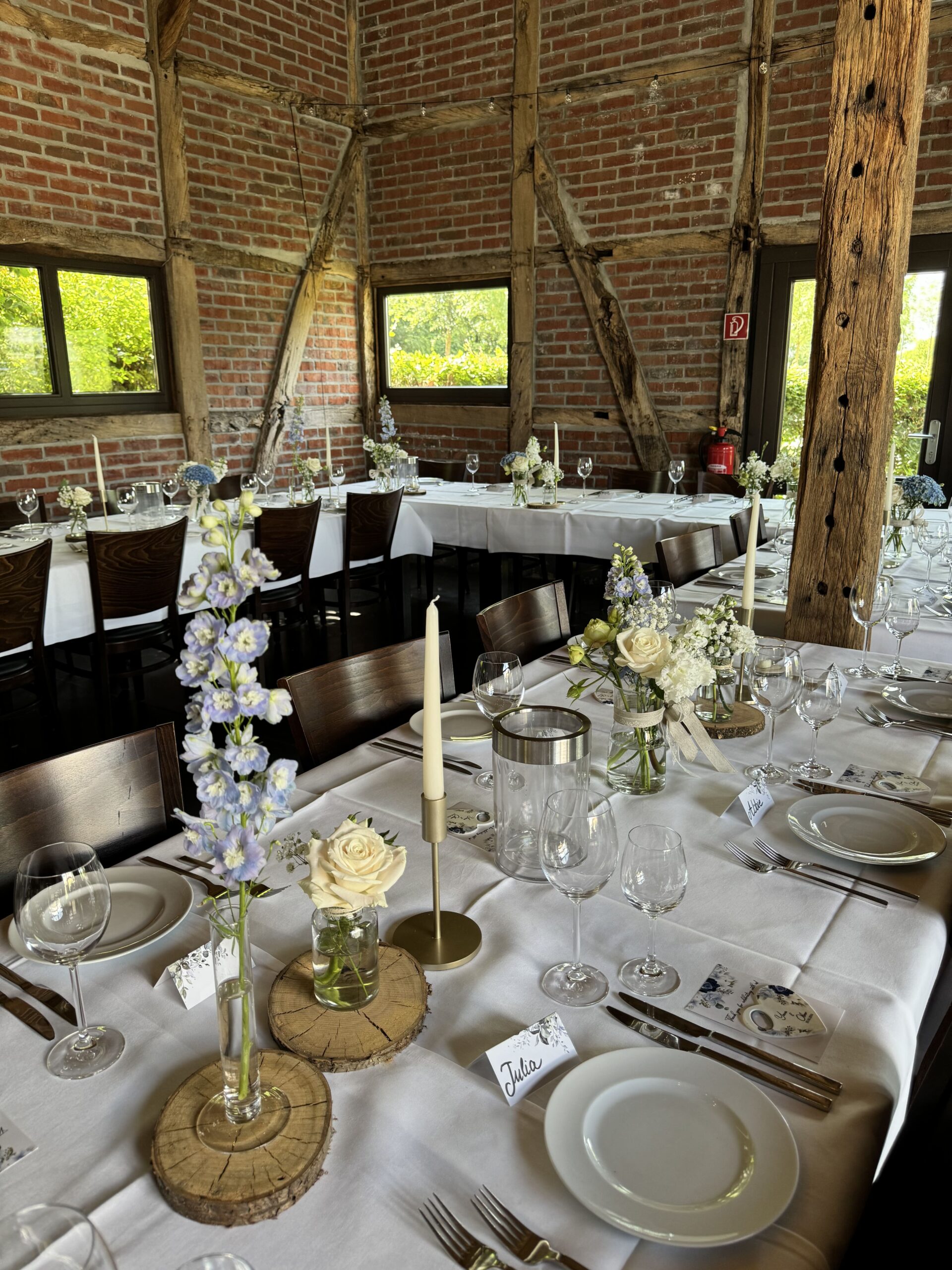 Gedeckte Gästetische einer Hochzeit in einem rustikalen Lokal