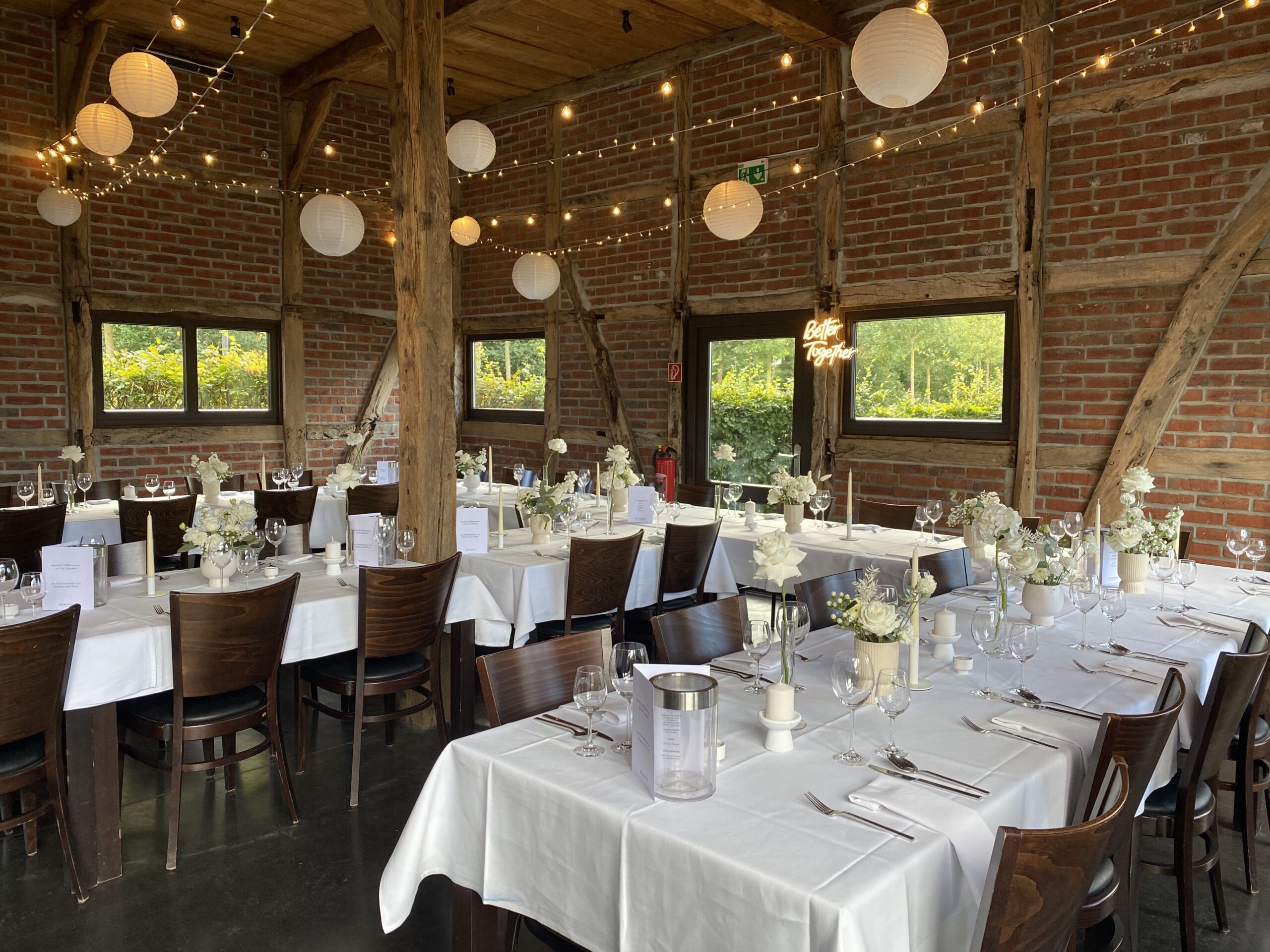 Gedeckte Tische mit leuchtenden Papierkugeln an der Decke